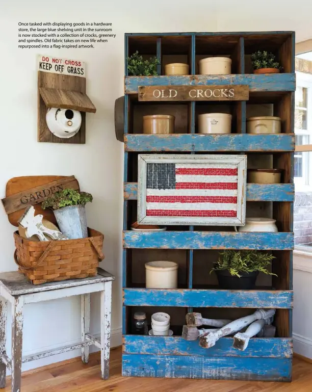  ??  ?? Once tasked with displaying goods in a hardware store, the large blue shelving unit in the sunroom is now stocked with a collection of crocks, greenery and spindles. Old fabric takes on new life when repurposed into a flag-inspired artwork.