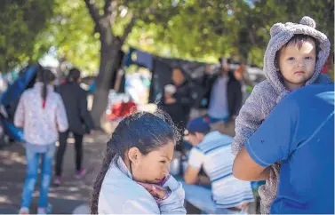  ?? ROBERTO E. ROSALES/JOURNAL ?? Two sisters from the state of Michoacan are among hundreds of young children living in a migrant camp in the Chamizal National Park near an internatio­nal bridge in Ciudad Juárez. The youngest girl wears a donated fleece teddy bear suit to keep warm. Their parents said they escaped from a town in Michoacan, controlled by drug cartels and are on a waiting list to enter the U.S. to ask for asylum.