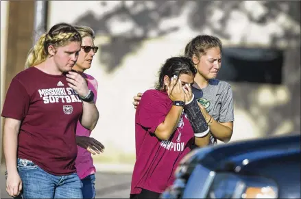  ?? AMANDA VOISARD / AMERICAN-STATESMAN ?? Friends and family of victims of the Santa Fe High School shooting walk out of the Fritz Barnett Intermedia­te School in Santa Fe, where they went to get updates on missing loved ones on Friday. Ten people were killed and 10 injured in the shooting.