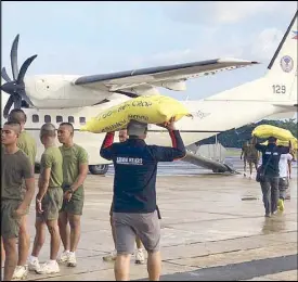  ?? JOHN UNSON ?? Relief workers load rice bags, to be distribute­d to fire victims in Jolo, onto a military aircraft at the Maguindana­o airport on Wednesday.