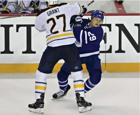  ?? AARON LYNETT/TORONTO STAR ?? The Maple Leafs’ William Nylander takes a hit from Sabres forward Derek Grant in during pre-season play in St. Catharines on Thursday night.