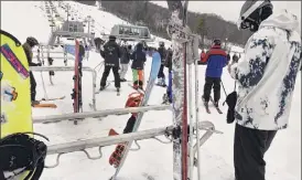  ??  ?? Skiers head to a lift on Monday at West Mountain in Queensbury.