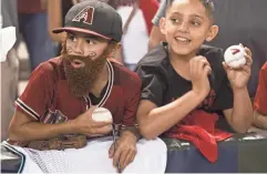  ?? PATRICK BREEN/THE REPUBLIC ?? Fans Marcelo Quezada (left) and Estevan Alicea wait for the Diamondbac­ks to take the field during Monday’s Game 3 against the Dodgers.