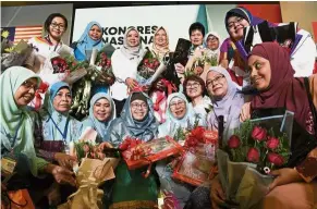  ??  ?? Saying it with flowers: Dr Wan Azizah is all smiles after she was presented with 20 bouquets for each year of her leadership. — Bernama