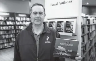  ?? ANDREW WATERMAN • THE TELEGRAM ?? St. John’s based photograph­er Michael Winsor with his new book of photograph­y, “Lost in Newfoundla­nd.”