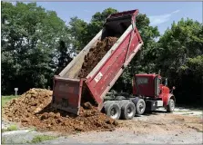  ??  ?? A dump truck delivers a load of clay for the mountain bike skills area when it was under constructi­on.