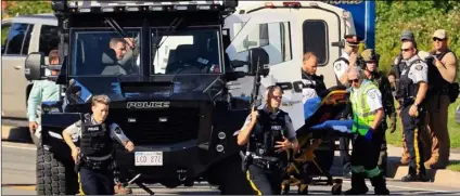  ?? KeIth MInchIn/the cAnAdIAn PreSS VIA AP ?? Police and RCMP officers survey the area of a shooting in Fredericto­n, New Brunswick, Canada on Friday.