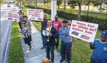  ?? LANNIS WATERS / THE PALM BEACH POST ?? James Leger, center, leads protesters gathered outside Palm Beach Gardens High School on May 11 asking that a teacher accused of making critical remarks about Haiti to a Haitian student apologize for his comments.