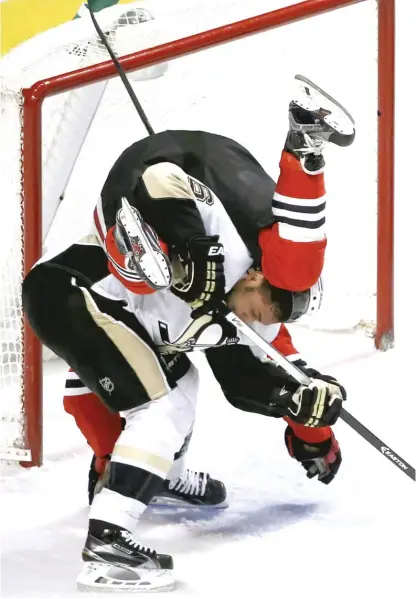  ?? | AP ?? Pittsburgh Penguins defenseman Trevor Daley upends Hawks forward Dennis Rasmussen in the first periodWedn­esday night.