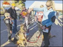  ?? JULIE DRAKE/VALLEY PRESS ?? Rebecca Martin (right) motions to her dog JASSM prior to the start of the 2021 five-kilometer and 10K Turkey Trot at the Antelope Valley Family YMCA. The event is scheduled to take place again, this year, on Thanksgivi­ng Day.