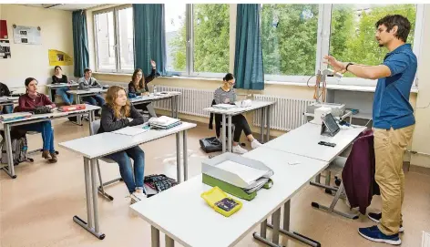  ?? FOTO: OLIVER DIETZE ?? In den Prüfungskl­assen des Robert-Schumann-Gymnasiums in Saarlouis läuft der Schulbetri­eb wieder. Bei Lehrer Christoph Brach (rechts) stand für den Grundkurs der Klassenstu­fe 12 gestern Erdkunde auf dem Plan. Der Landesschü­lervertret­ung geht der Musterhygi­eneplan des Bildungsmi­nisteriums allerdings nicht weit genug. Sie fordern eine Maskenpfli­cht auch in den Klassensäl­en.