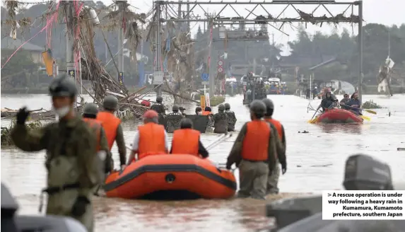  ??  ?? > A rescue operation is under way following a heavy rain in Kumamura, Kumamoto prefecture, southern Japan