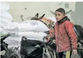  ?? FOTO: TALATENE/DPA ?? Ein Junge erhält vom UN-Palästinen­serhilfswe­rk UNRWA Nahrungsmi­ttel. Nun gibt es Vorwürfe, dass zwölf Beschäftig­te des Hilfswerks in das Massaker am 7. Oktober verwickelt sein sollen.