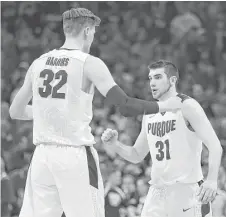  ?? Elsa / Getty Images ?? Purdue’s Dakota Mathias, right, made a key 3-pointer with 14.2 seconds left, lifting Matt Haarms and their teammates to victory.