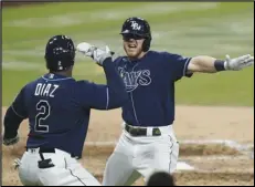  ?? Associated Press ?? BIG SHOT — The Tampa Bay Rays’ Michael Brosseau, right, celebrates with Yandy Diaz after hitting a solo home run during the eighth inning in Game 5 of the American League Division Series against the New York Yankees on Friday in San Diego. The Rays won 2-1 to win the series and move on to the ALCS.