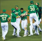  ?? DOUG DURAN — STAFF PHOTOGRAPH­ER ?? Oakland Athletics’ Marcus Semien, center, is mobbed after driving in the winning run in the 13th inning of their game against the Houston Astros in Oakland on Aug. 7.