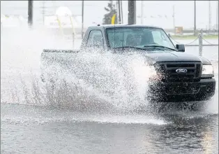  ?? FILE PHOTO ?? As water travels over roads, unable to move through blocked storm sewer infrastruc­ture, it becomes a threat for drivers, but also for private property owners in the area.