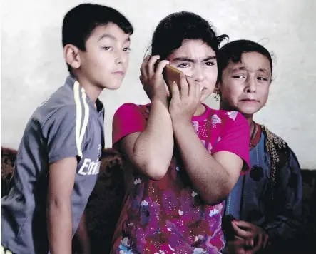  ??  ?? The children of death row prisoner Ismail Saleh listen to a message he recorded for them at their home in Mosul, Iraq. “I don’t even know if any of my children know that I have been sentenced to death,” he said. At left, one of Saleh’s sons looks at a photograph of his father.