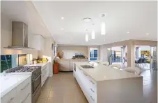  ??  ?? FLAWLESS DESIGN: The stunning, large galley kitchen (with island bench) is appointed with quality appliances and frosted-glass feature cabinet doors, stone bench tops, a dishwasher and a gas cook top.