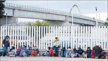  ?? Alejandro Tamayo San Diego Union-Tribune ?? CENTRAL AMERICAN migrants wait at the U.S.-Mexico border in Tijuana to make their appeal for asylum.