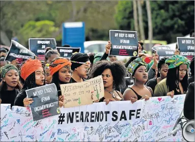  ?? Picture: EUGENE COETZEE ?? LIVING IN FEAR: NMMU students carry a poster with thousands of signatures