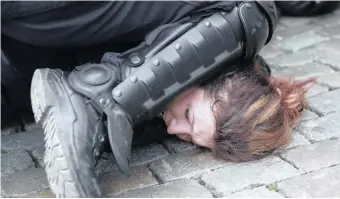  ??  ?? POLICE detain a woman during a yellow vest protest with other groups in Brussels. The death of George Floyd has renewed scrutiny of immobiliza­tion techniques long used in policing around the world. | AP
RIGHT: A file frame from video shows a Minneapoli­s officer kneel on the neck of George Floyd, a handcuffed man who was pleading that he could not breathe. | AP