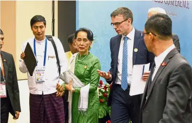  ?? — AP ?? Important talks: Suu Kyi talking with Estonia Foreign Minister and a representa­tive of EU Sven Mikser (second right) as they leave a press conference after the Asia Europe Foreign Ministers meeting at Myanmar Internatio­nal Convention Centre.