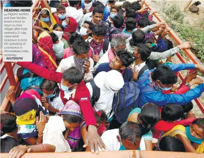  ??  ?? HEADING HOME ... Migrant workers and their families board a truck to return to their villages after India ordered a 21-day nationwide lockdown to limit the spreading of coronaviru­s in Ahmedabad, India, yesterday. – REUTERSPIX