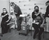  ?? Lisa Krantz / Staff photograph­er ?? Dr. Ericka Gullion, left, gets the COVID-19 vaccine along with Dr. Marlene Sanchez in December.