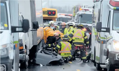  ?? DAVE JOHNSON/WELLAND TRIBUNE ?? Welland Fire and Emergency Services firefighte­rs work with Niagara Emergency Medical Services paramedics to free a man from a car partially pinned under a cube van on Highway 140 just north of Buchner Road on Tuesday morning. An Ornge air ambulance...