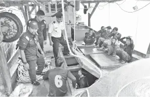  ??  ?? (gambar atas) ANGGOTA APMM memeriksa nelayan Vietnam yang ditahan dalam Ops Permai pada petang Khamis lalu.