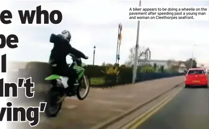  ??  ?? A biker appears to be doing a wheelie on the pavement after speeding past a young man and woman on Cleethorpe­s seafront.