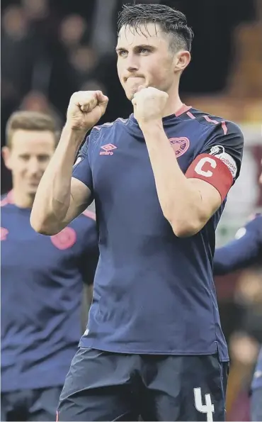  ??  ?? 0 John Souttar, with the captain’s armband, applauds the travelling Hearts supporters on Saturday.