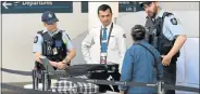  ?? Picture: AFP ?? EXTRA MEASURES: Police help screen passengers at Sydney Airport yesterday