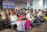  ?? AP/HADI MIZBAN ?? Stranded travelers sit and wait Tuesday at Hamad Internatio­nal Airport in Doha, Qatar. Flights were canceled after Qatar’s Persian Gulf neighbors and other Arab countries cut diplomatic ties.