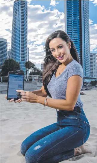  ?? Picture: JERAD WILLIAMS ?? Charlotte Cush from Robina enjoys reading the Gold Coast Bulletin on her Samsung tablet while relaxing on the beach in Surfers Paradise.