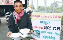  ?? (Reuters) ?? TUON TEM, 49, holds a bowl of porridge outside his restaurant in Siem Reap province, Cambodia, yesterday.