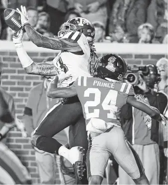  ?? Thomas Graning / Associated Press ?? Texas A&M wide receiver Kendrick Rogers comes down with a touchdown pass over Mississipp­i defensive back Deantre Prince late in the first half of the Aggies’ road win on Saturday night.