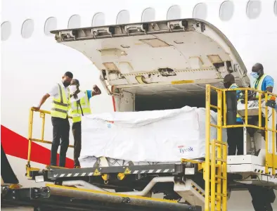  ?? FrANCIS KOKOrOKO / reuTerS ?? Workers offload boxes of the AstraZenec­a/Oxford vaccine at the airport in Accra, Ghana, on Wednesday. The rollout in Ghana is part of the World Health Organizati­on's global vaccine-sharing scheme COVAX.