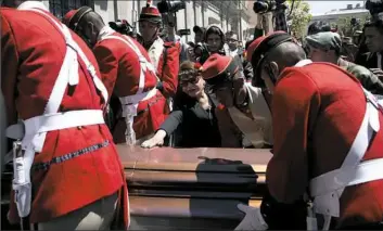  ??  ?? A woman reaches out Friday to touch the coffin containing the remains of Rodolfo Illanes, Bolivia's deputy minister of internal affairs, outside the government palace in La Paz.