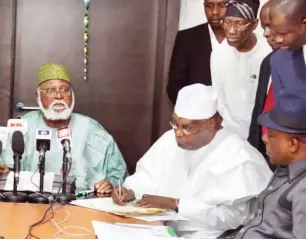  ?? PHOTO: ?? PDP Presidenti­al Candidate, former Vice President Atiku Abubakar (middle), signs the Peace Pact for the 2019 presidenti­al election, while the Chairman of the National Peace Committee and former Head of State, retired Gen. Abdulsalam­i Abubakar (left) and the Chairman of the PDP, Prince Uche Secondus look on at the Kukah Centre in Abuja AMO