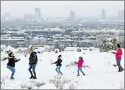  ?? Ethan Miller Getty Images ?? RESORTS along the Las Vegas Strip are seen in the distance on Thursday as people enjoy the snow.