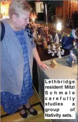  ??  ?? Lethbridge resident Mitzi Schmale carefully studies a group of Nativity sets.