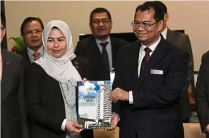  ?? — Bernama ?? Important informatio­n: Nik Azman (right) and Noraini holding a copy of the 2018 Auditor-General’s Report at the Parliament building in Kuala Lumpur.