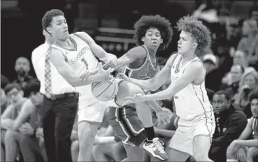  ?? Jose Luis Villegas For The Times ?? HARVARD-WESTLAKE’S Robert Hinton, middle, knocks the ball away from St. Joseph’s Julius Price, left, as Luis Marin tries to help in the first quarter of the Wolverines’ 76-65 win in the Open Division title game.