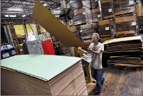  ?? Dallas Morning News/BEN TORRES ?? A Pollock worker places a large piece of cardboard on a stack of folded packages before they are shipped out of the plant in Grand Prairie, Texas.