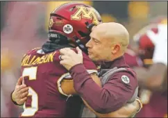  ?? (File Photo/AP/Stacy Bengs) ?? Fleck hugs defensive back Chris Williamson (6) during an NCAA college football game against Wisconsin, in Minneapoli­s in November 2019. Fleck has never lacked for clever ways to connect and motivate his players.