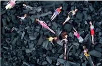  ?? AFP ?? Charred-stained dolls placed on a bed of charcoal are part of an artists’ installati­on placed at the front gate of the presidenti­al house in remembranc­e of the victims of the fire. —