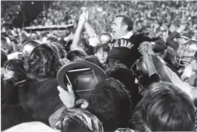  ?? AP file ?? Notre Dame players give coach Ara Parseghian a ride after the Irish defeated Alabama 24-23 in the Sugar Bowl to win the 1973 national championsh­ip.