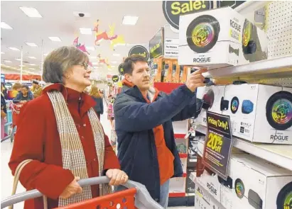  ?? KIM HAIRSTON/BALTIMORE SUN ?? Susan Kasbeer of Ormond Beach, Fla., and her son-in-law, Michael Kasbeer-Betty of Ellicott City, select a hoverboard during their Black Friday shopping trip to the Target in Ellicott City. Local stores reported business was brisk for the kickoff of holiday shopping.